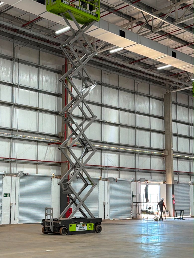 Plataforma tesoura da PEMTMAX elevada em galpão